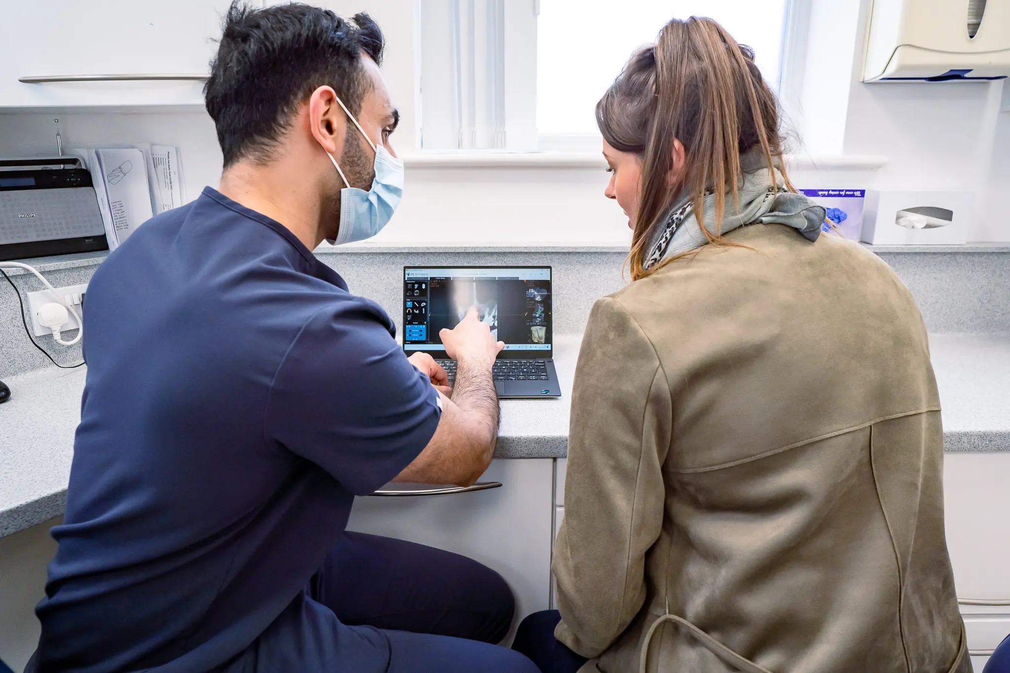 Dr. Nadeem Sabir discussing dental implant treatment with patient